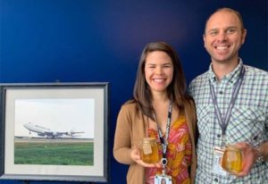 Captain Andrew Lutz and First Officer Blythe Nakasone deliver jars of honey made by bees in their apiary to their colleagues in CVG.