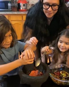 Christina prepares salsa with her daughters.