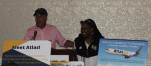 Gary Wade at the podium with Tameika Wiley of the Liberty City Optimist Club.