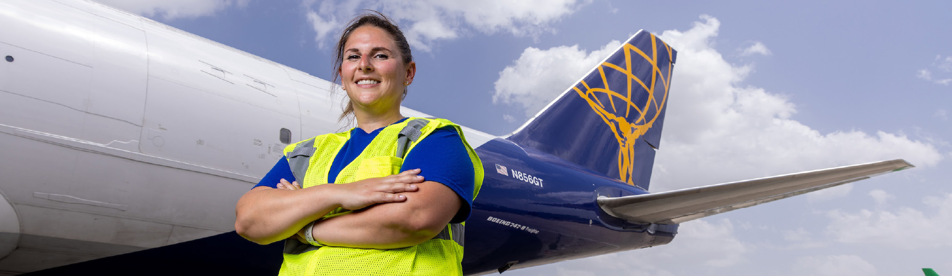 Atlas Employee standing with her arms crossed in front of a Boeing 747-8